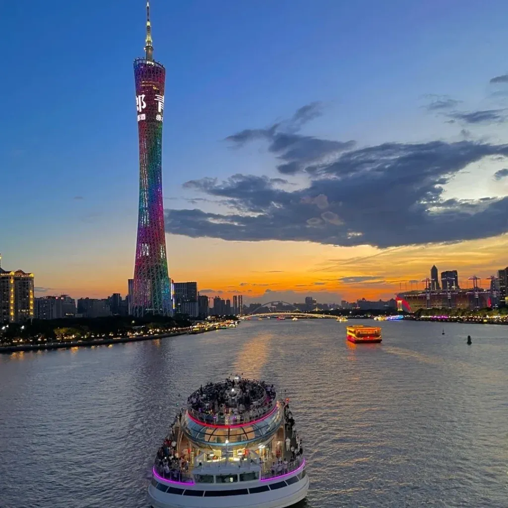 A-stunning-evening-view-of-the-Canton-Tower-in-Guangzhou-illuminated-in-vibrant-colors-with-a-cruise-ship-sailing-on-the-Pearl-River-at-sunset-e1723950338253-1024x1024.webp